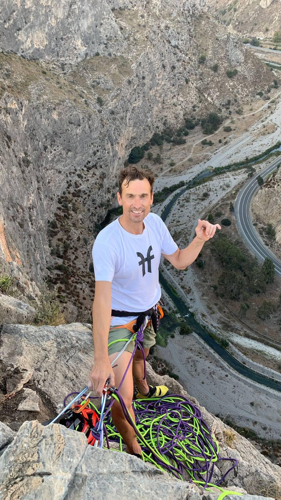 Kenton Cool abobe the Motril Gorge with a mass of ropes lying at his feet. below is a road and river