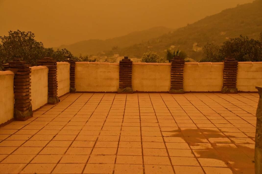 A dark orange mist covers the rooftops and landscape caused by the Calima "Sahara Dust"