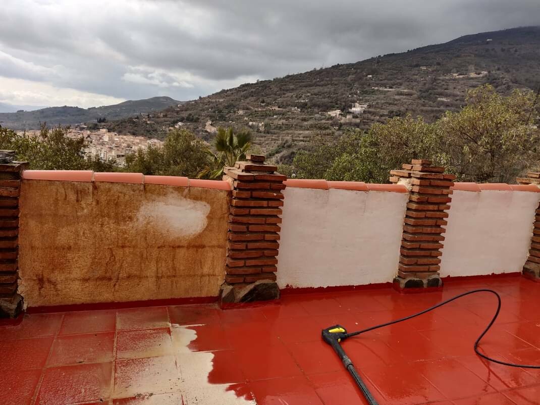 Contrast the clean white walls of a roof terrace with the dirty orange and brown walls that have been affected by a Sahara dust storm