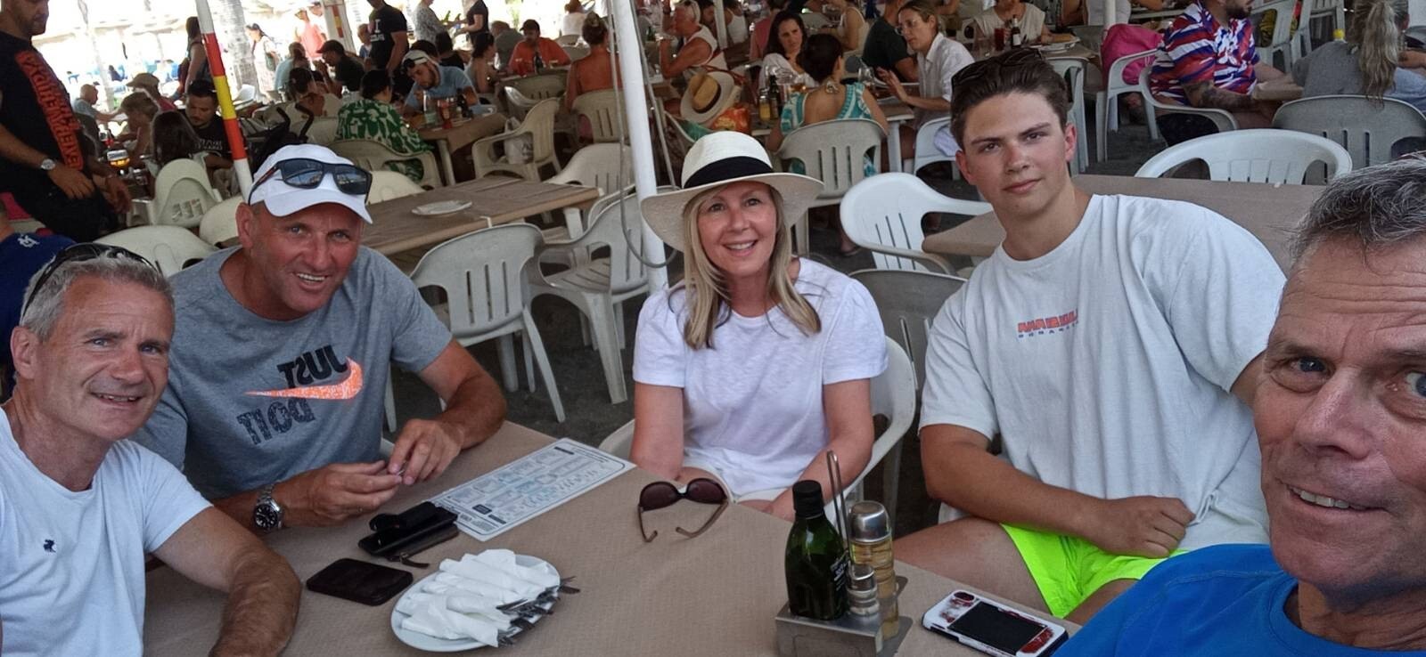 A group of people sit around a table in a busy restaurant in Nerja, Spain