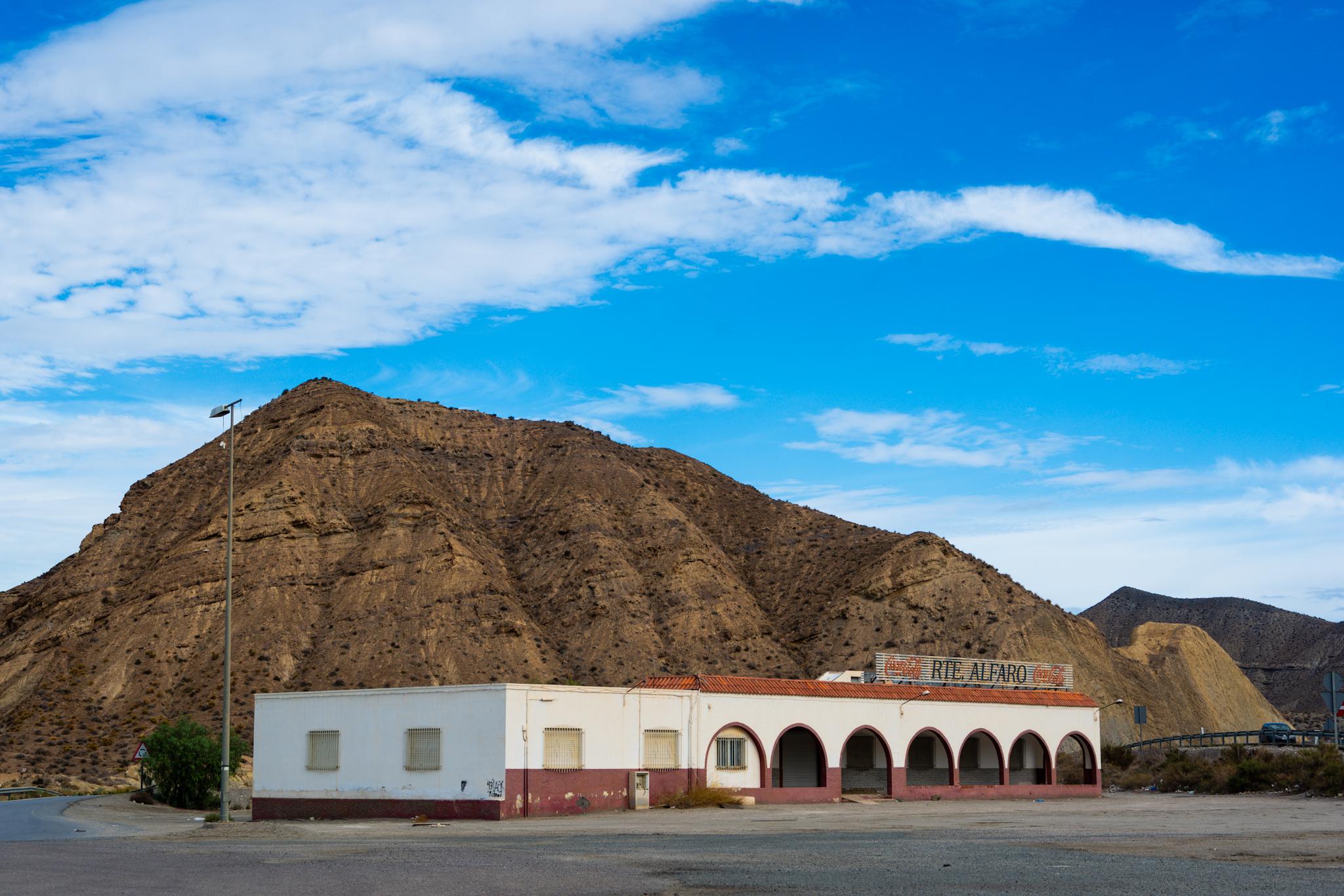 A white restaurant sits in front of an arid mountain