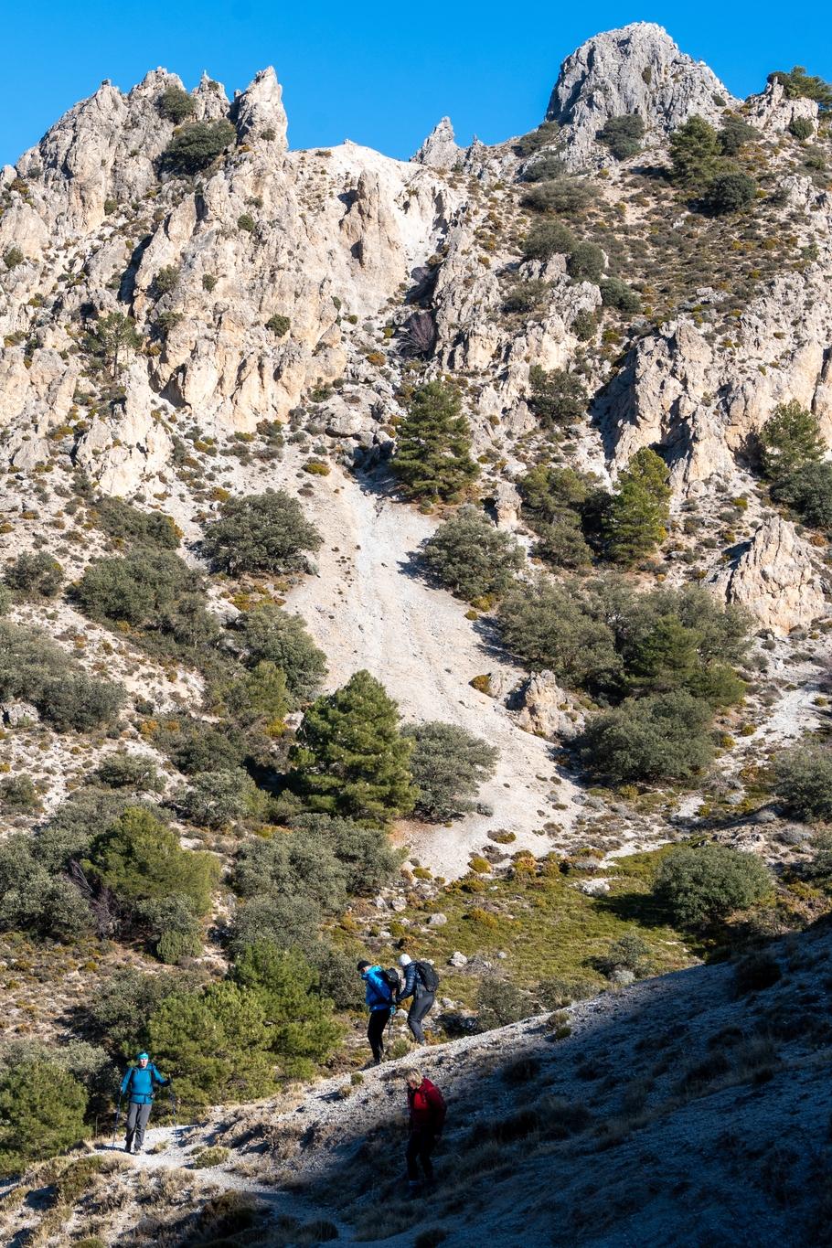 Hikers descending a sunlit ridge