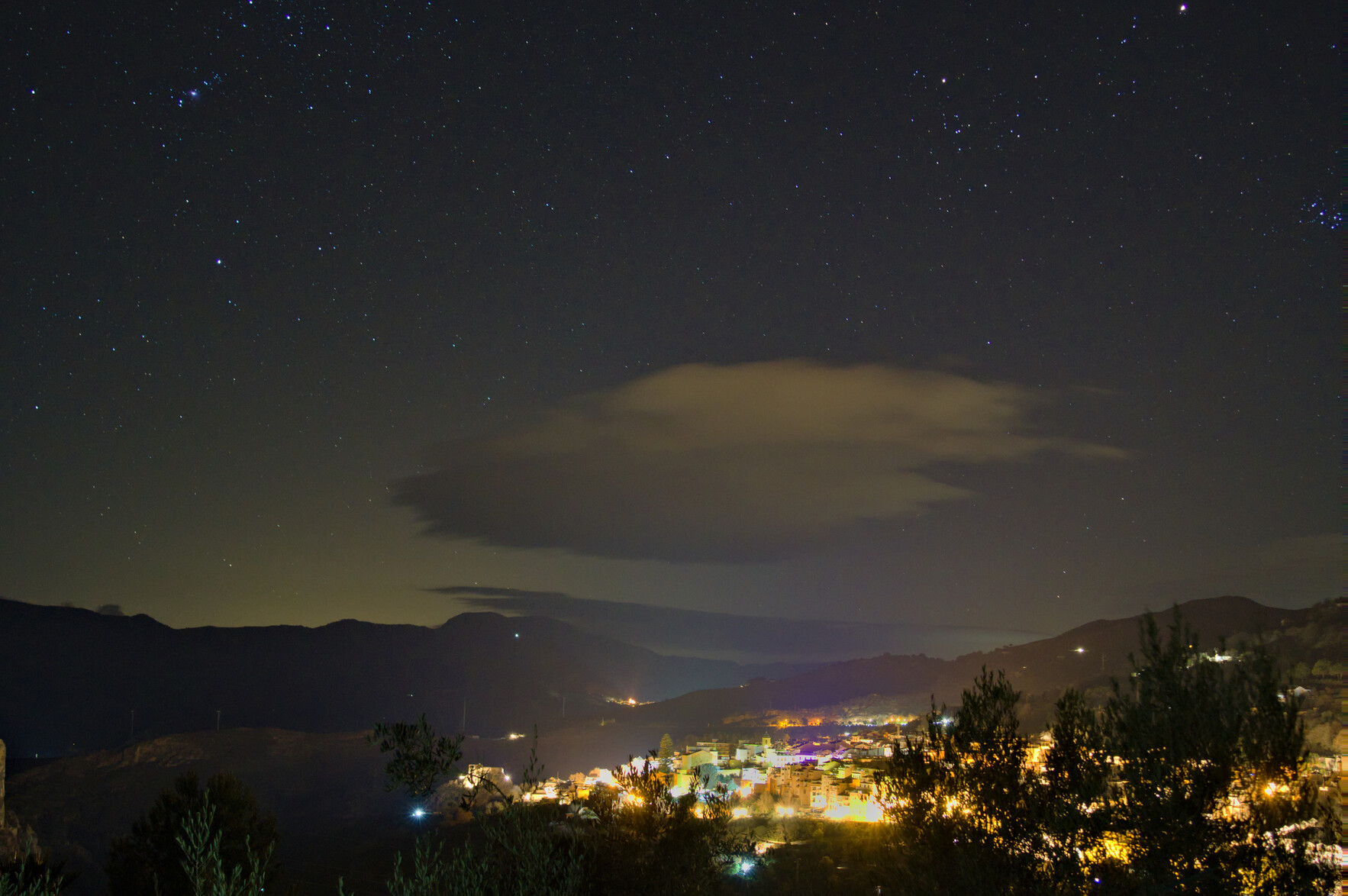 The town, Lanjarón, in southern Spain under the stars. The constallation of Orion to the top left and the Pleiades to the extreme right.