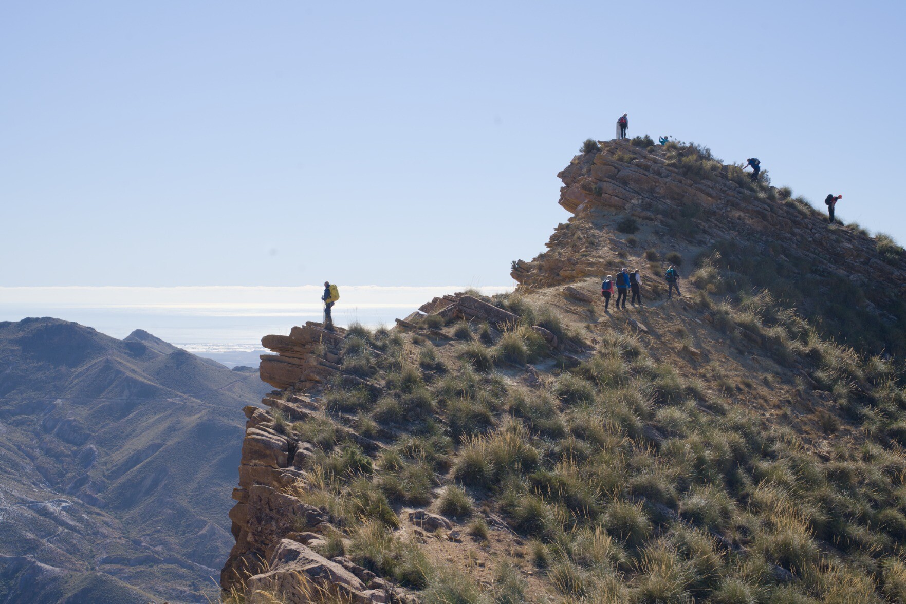 A group of hikers reaching the summit of a lofty peak in Spain