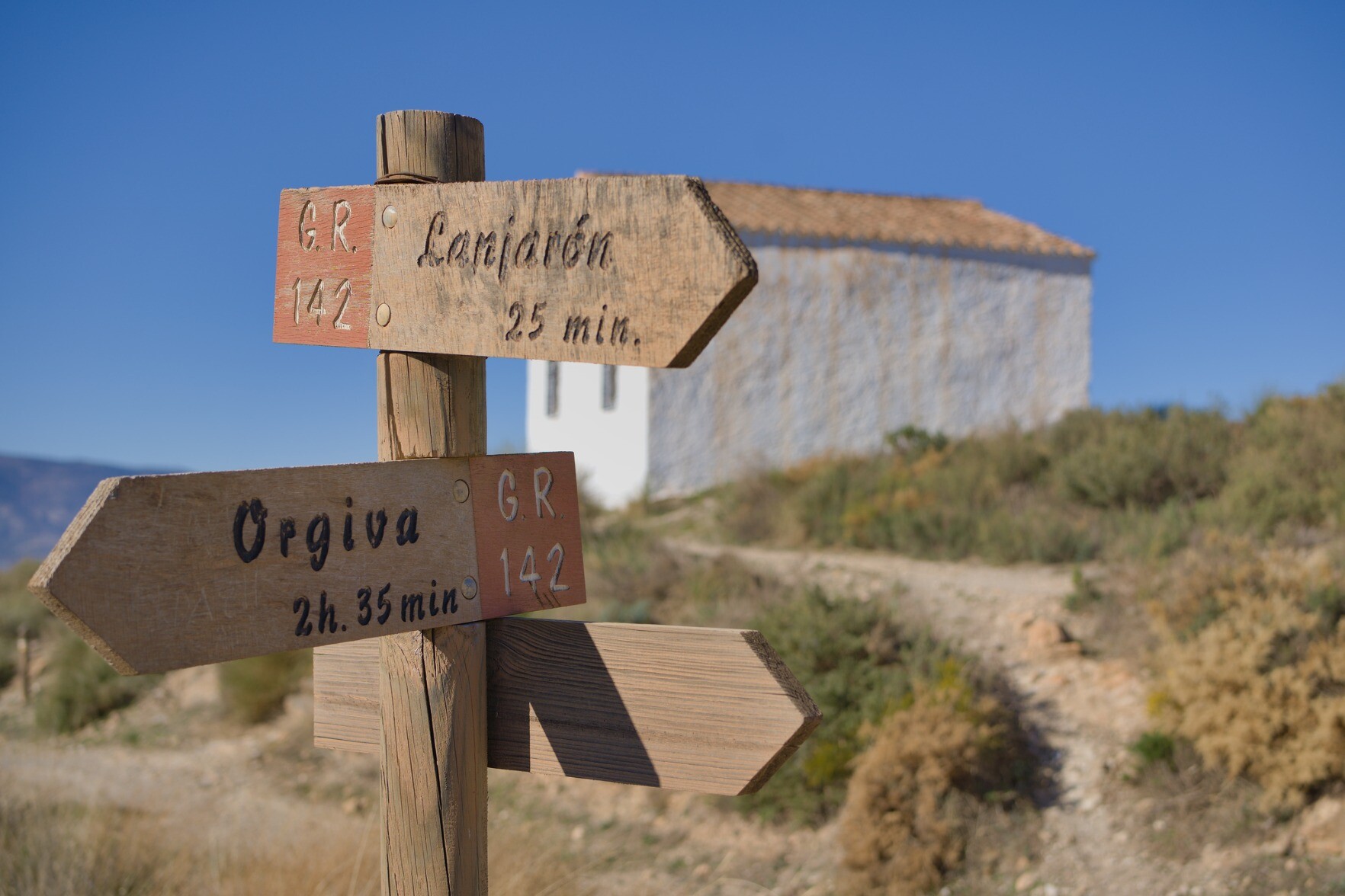 Signpost through the Alpujarras with a small church in the background