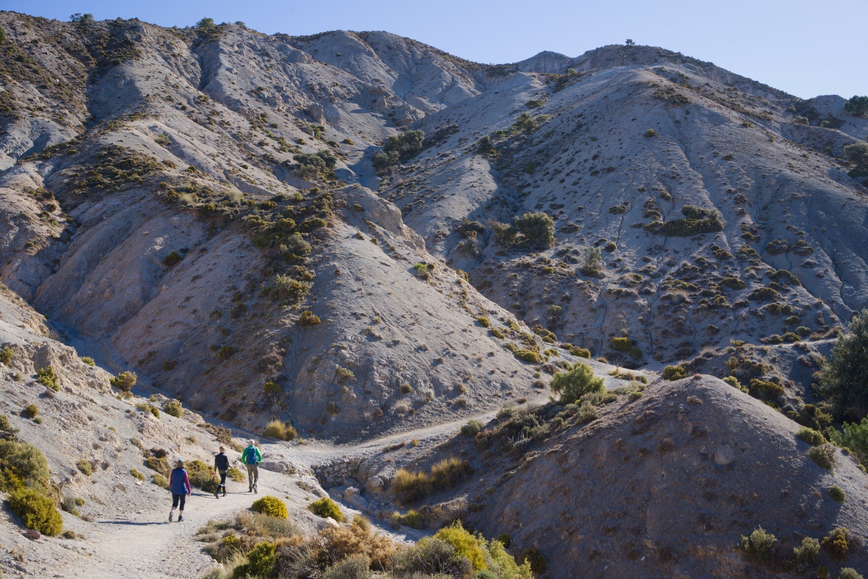 Hikers moving in an arid landscape near Granada, Spain