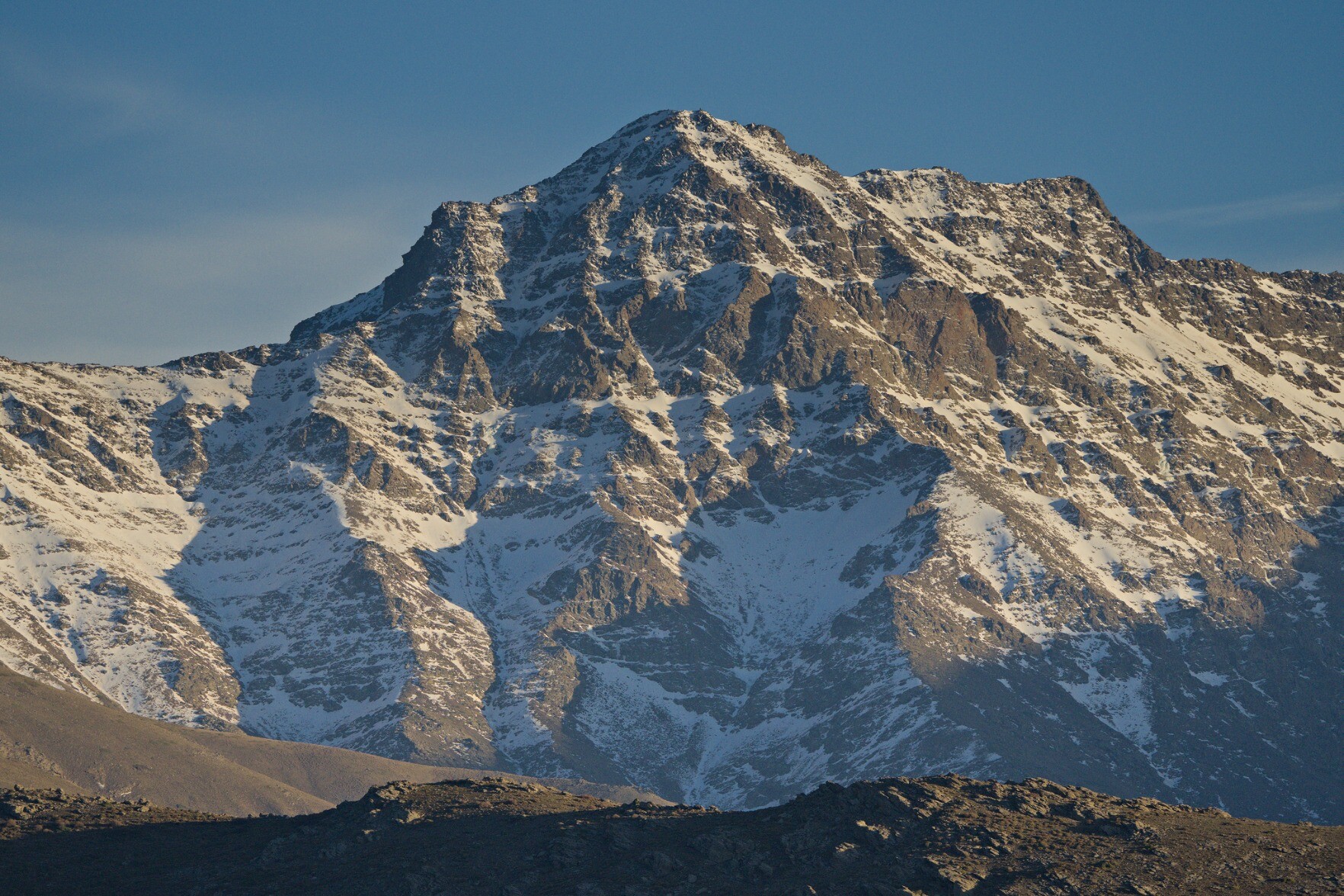 The peak of Alcazaba, a steep northern mountain face covered in snow