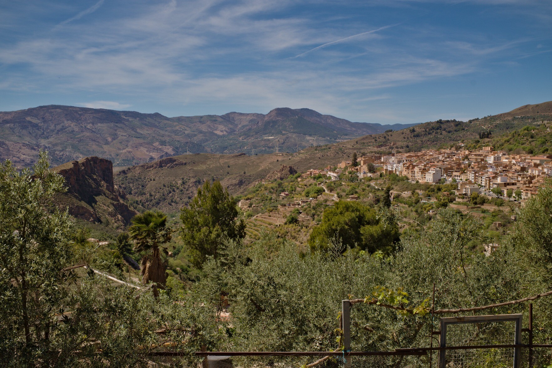 To the right is the town of Lanjaron in Andlaucia. Above is a blue sky with some whispy white clouds