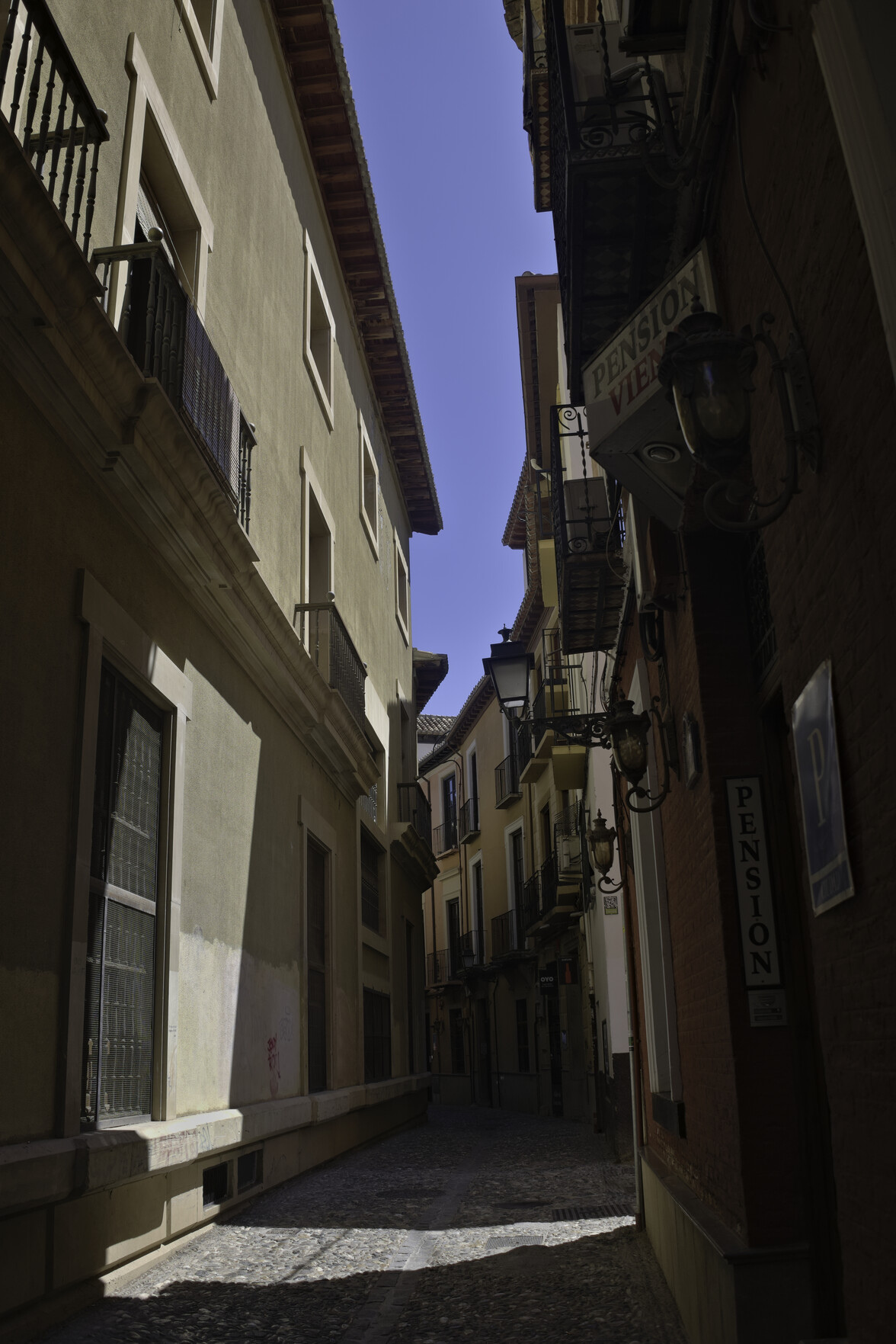 Another contrasting street scene of sun and shade, blue sky above