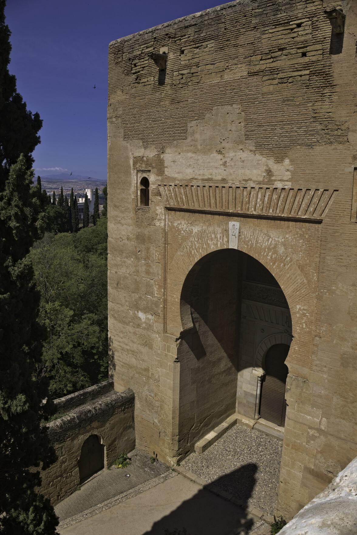 Large imposing gate with a horseshoe arch & entrance leading to the Palace of Carlos Quinto.
