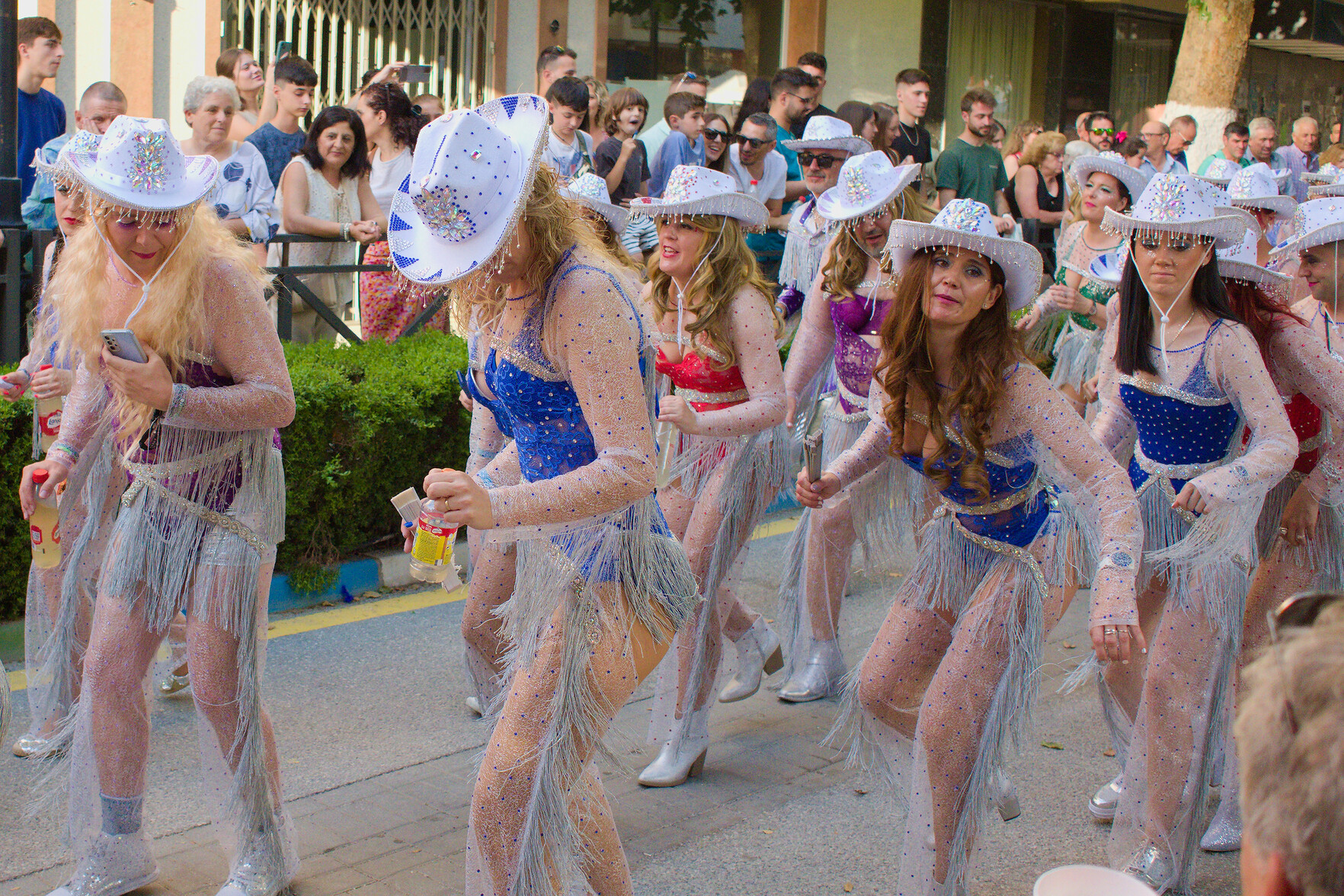 Some ladies dressed as cowgirls dance during a spanish carnival