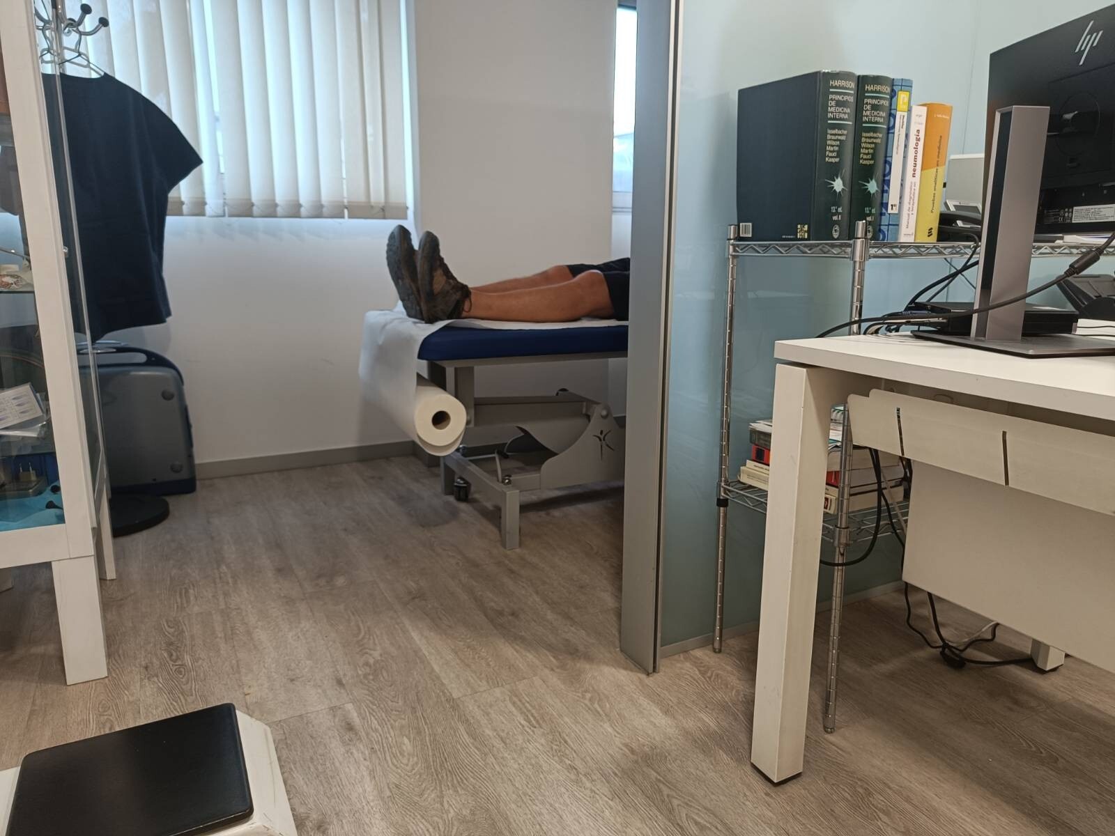 A pair of legs are sticking out from a hospital treatment bed