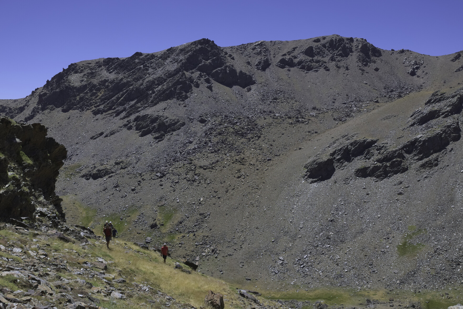 Pico Sabinar mountain is in the background. In the foreground can be seen some hikers climbing trail less hillsides
