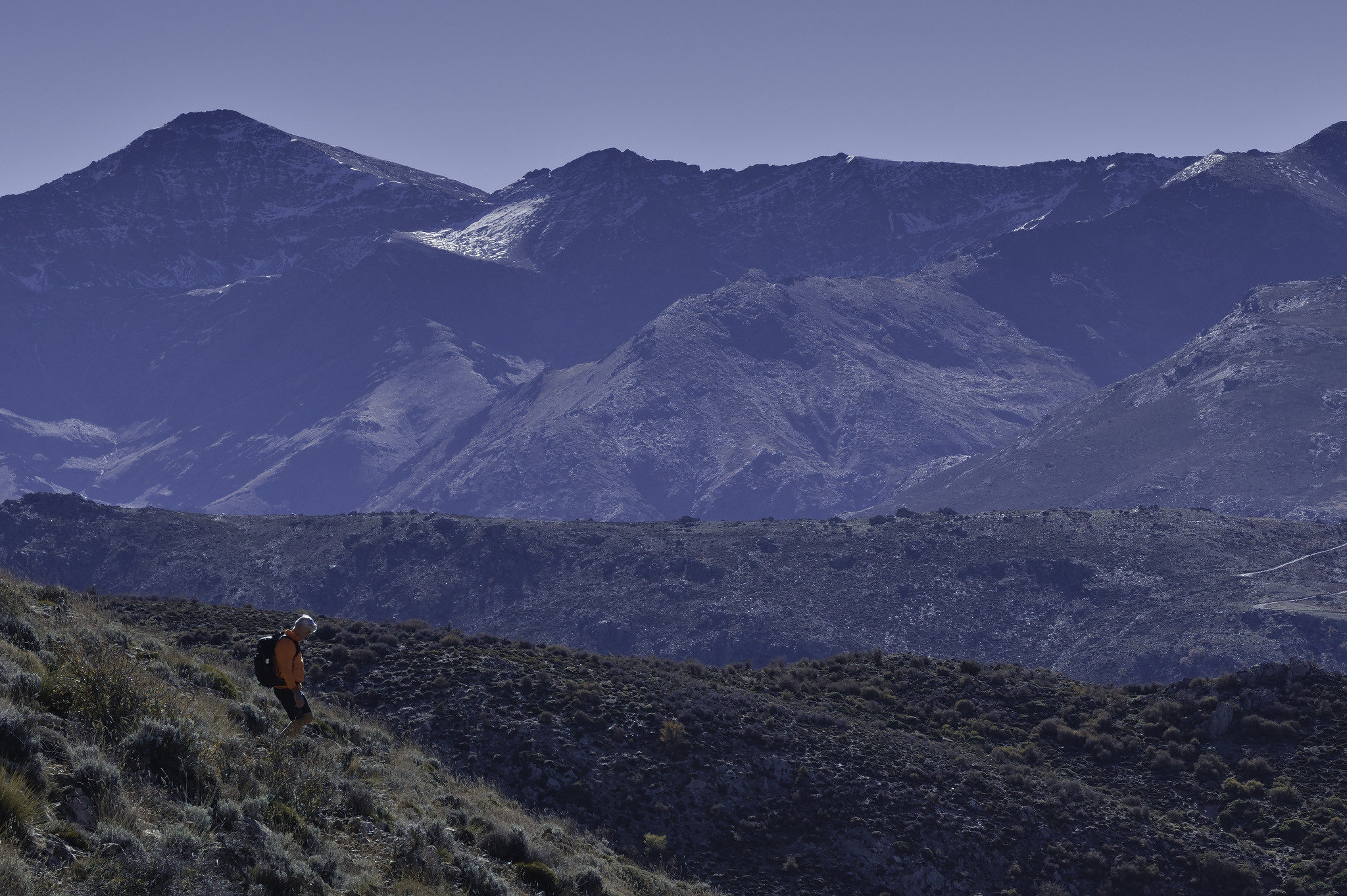 Sean James descends Alto de Miguelos slopes whilst behind rises the north face of Mulhacen, highest mountain in mainland Spain