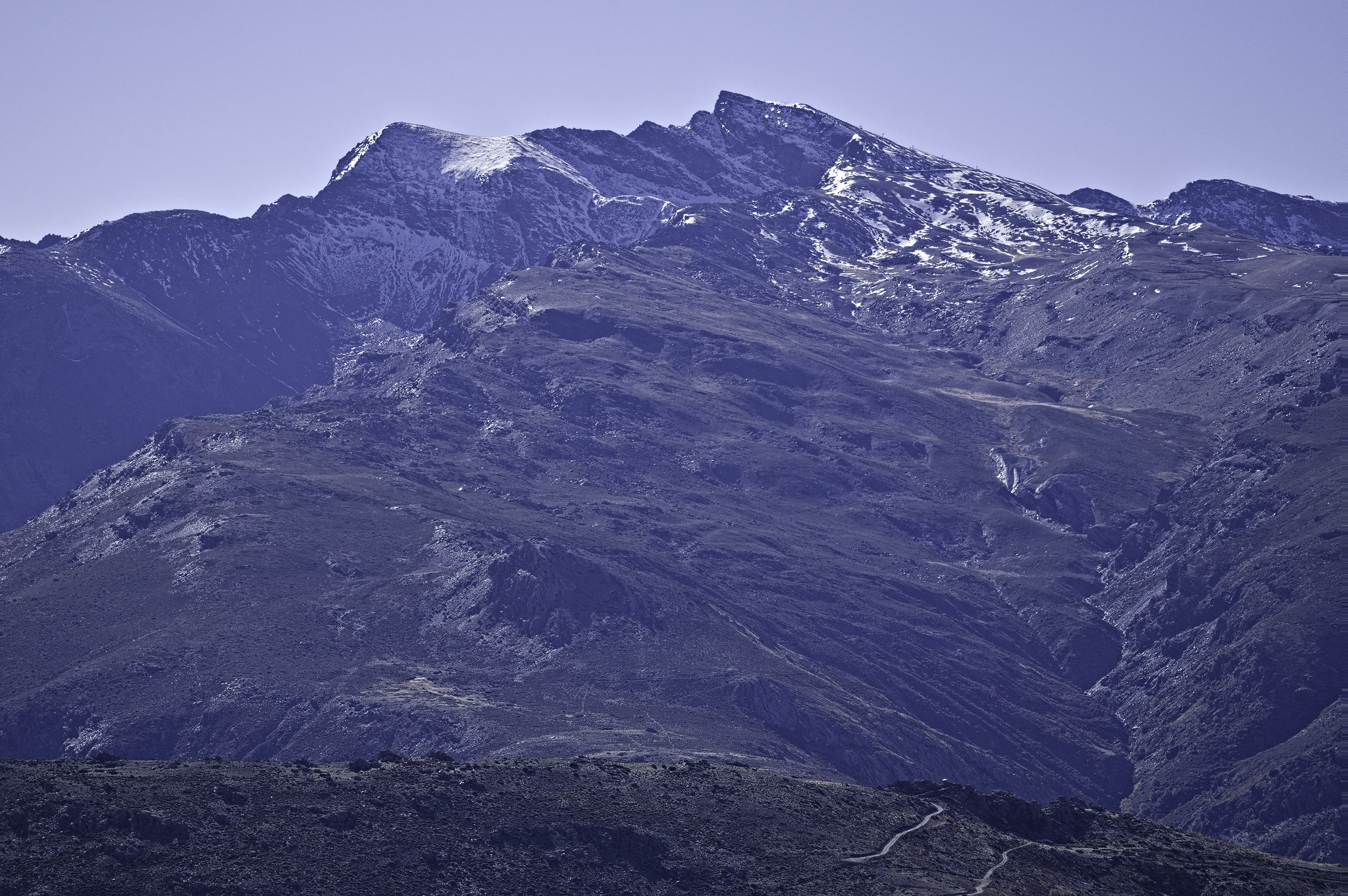 The north face of Veleta in Spain's Sierra Nevada. A jagged mountain ridge has some isolated early season snow patches
