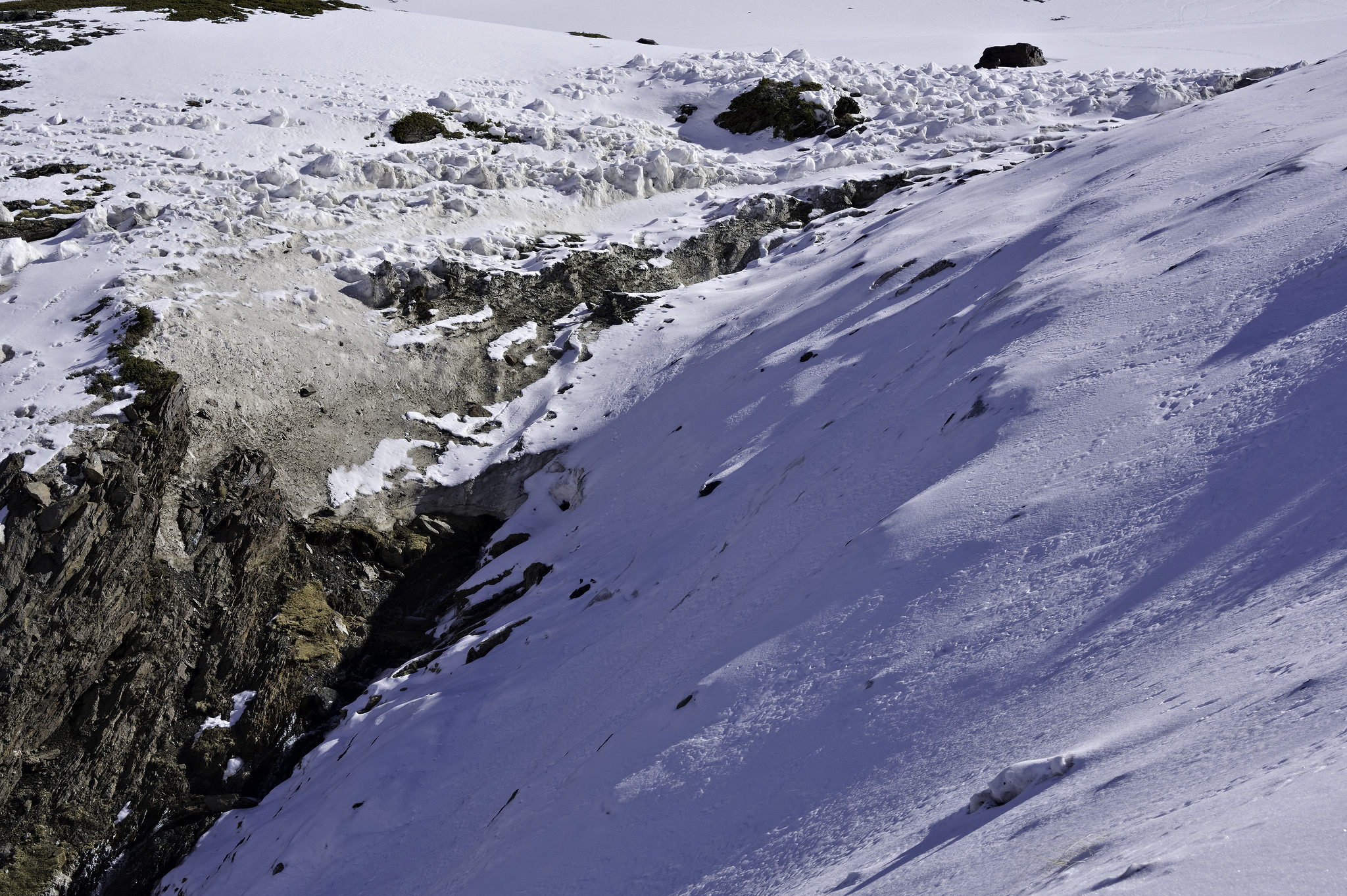 A stream bed has avalanched leaving blocks of snow above