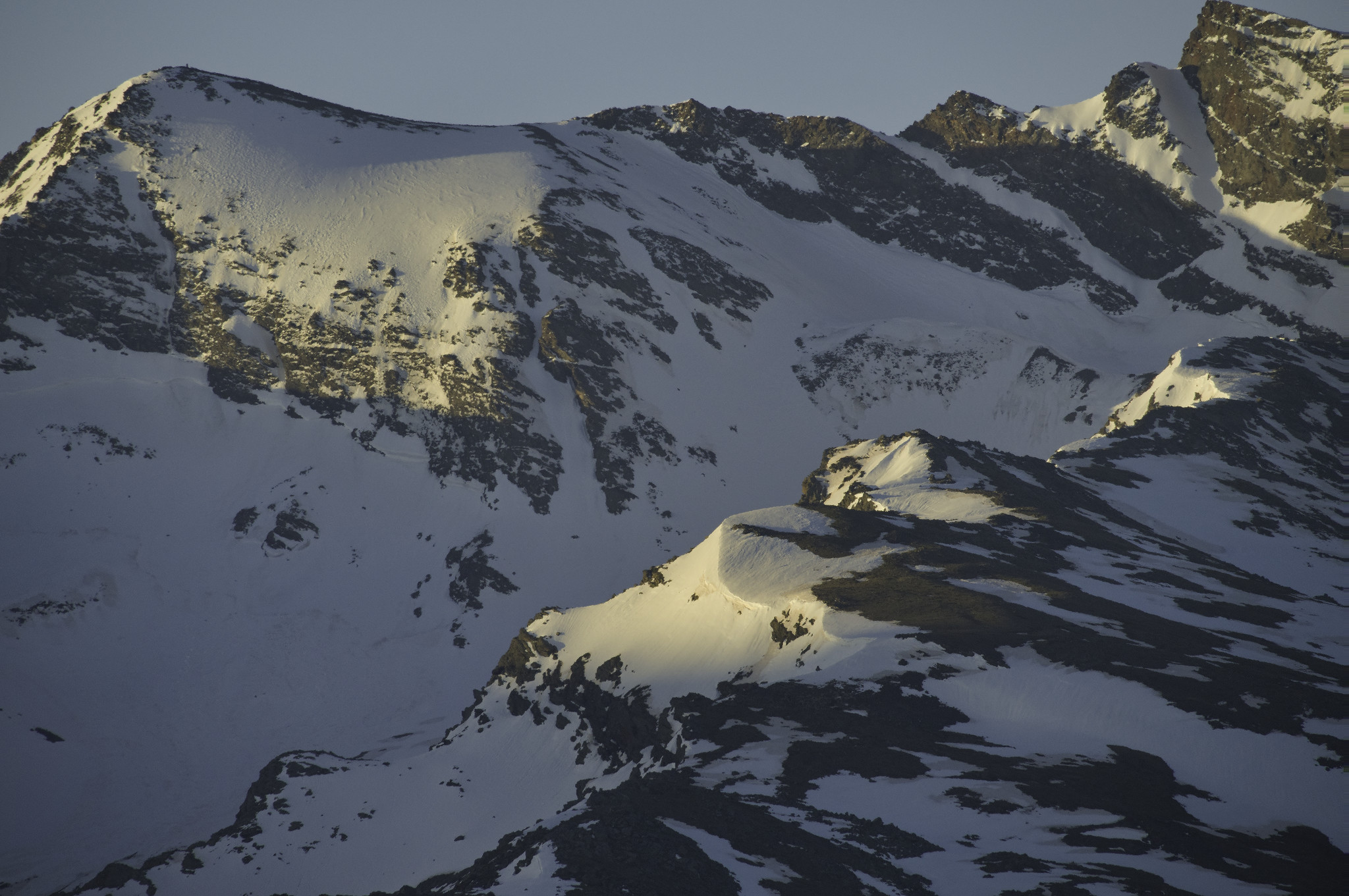 Ridges of rock and snow illuminated by the rising sun