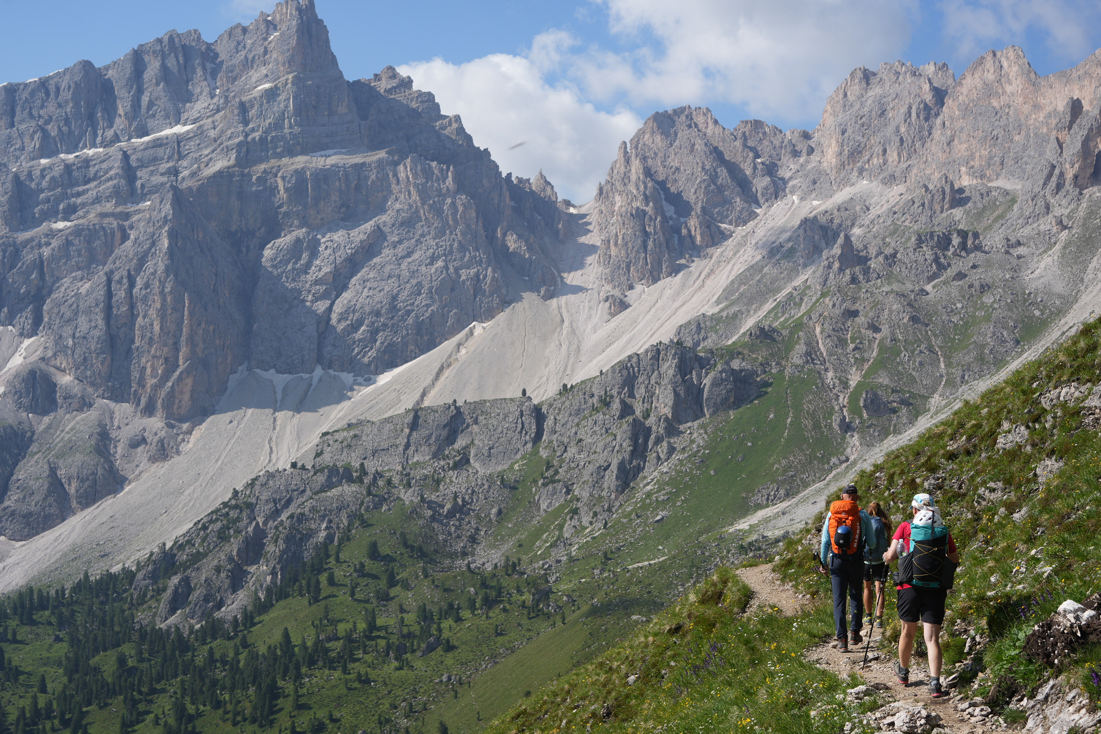Backpackers walk towards some distant mountain summits