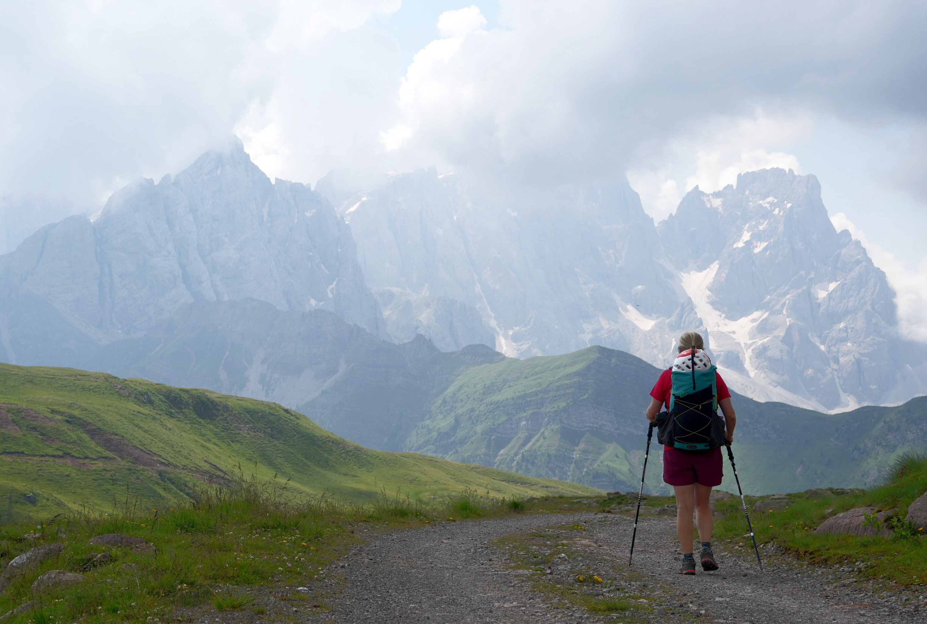 A hiker walks towards some distant mountains