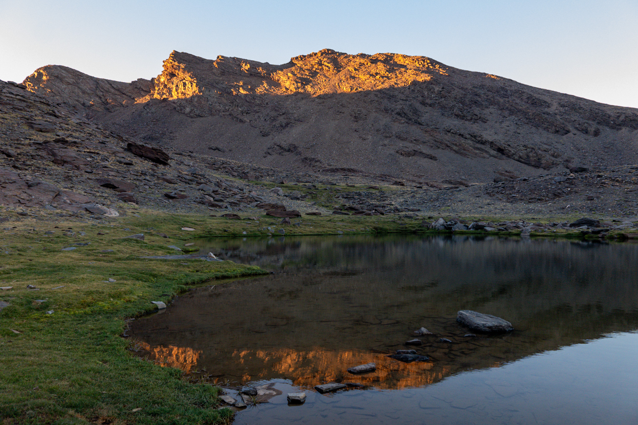 Evening sunlight reflected on the summit of Peñon del Globo and also in the lake below