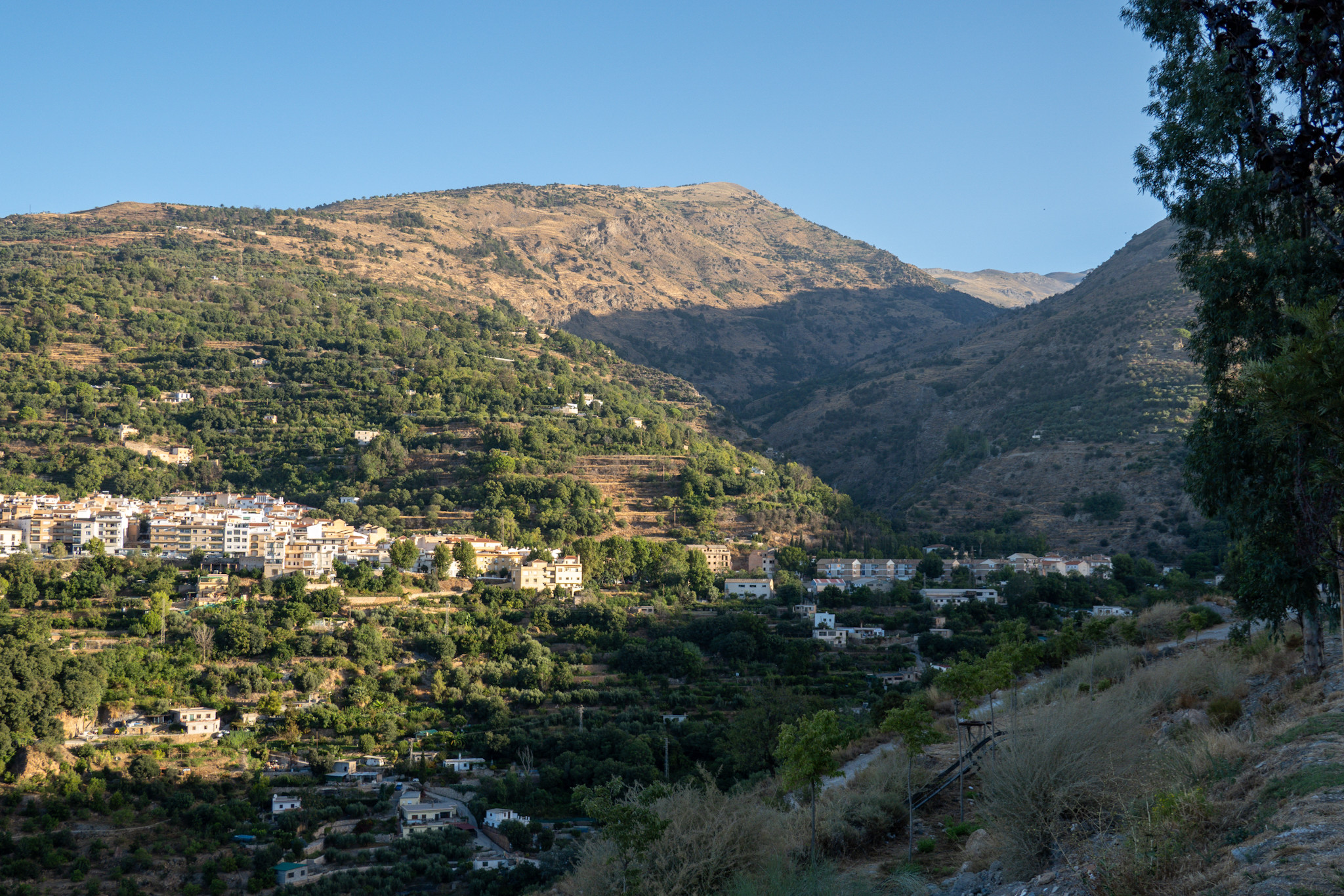 The Rio Lanjaron valley heading up towards the Sierra Nevada. On the left on sunlit slopes the outskirts of the town of Lanjaron