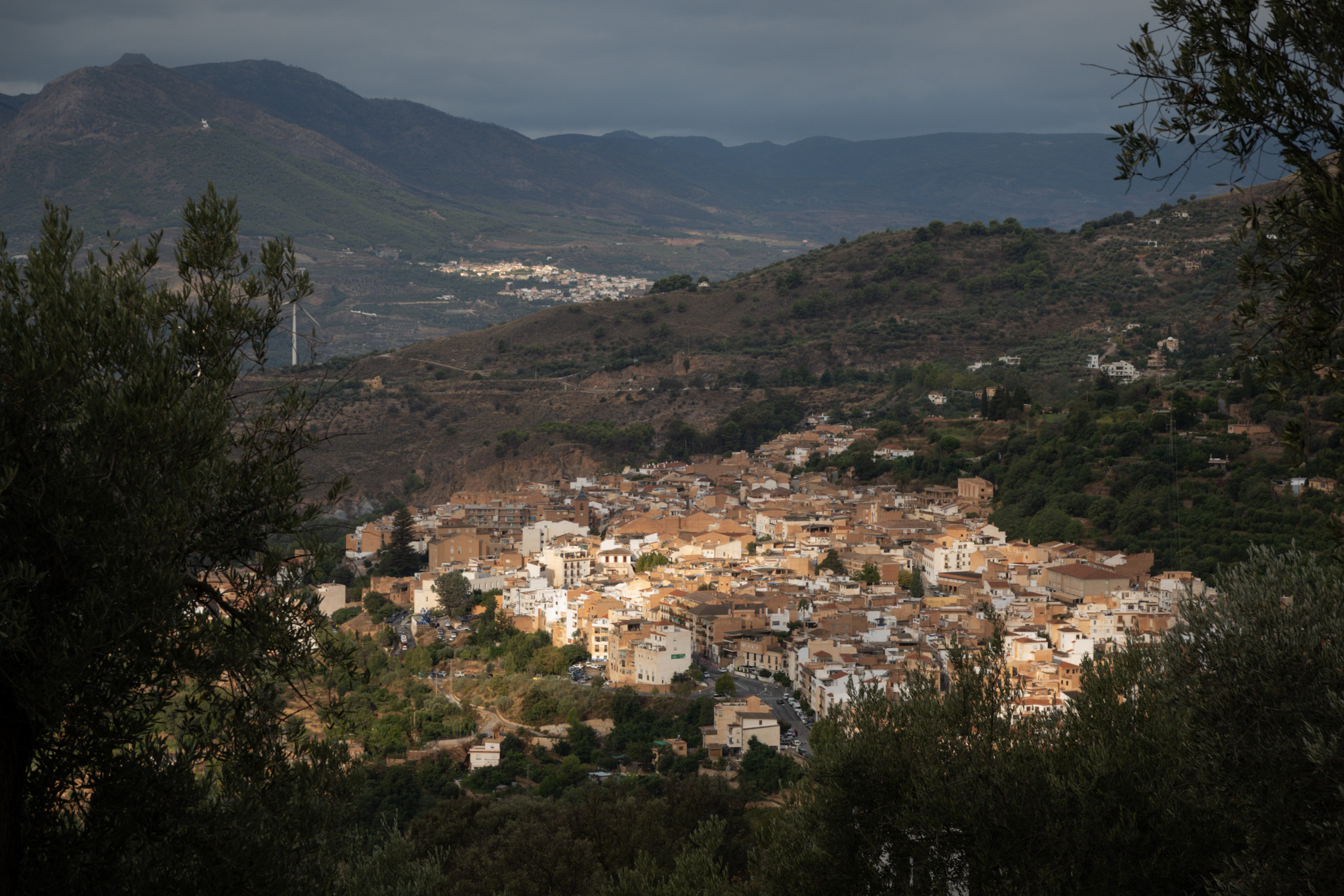 Sun shining on a small Spanish town. Cloudy all around