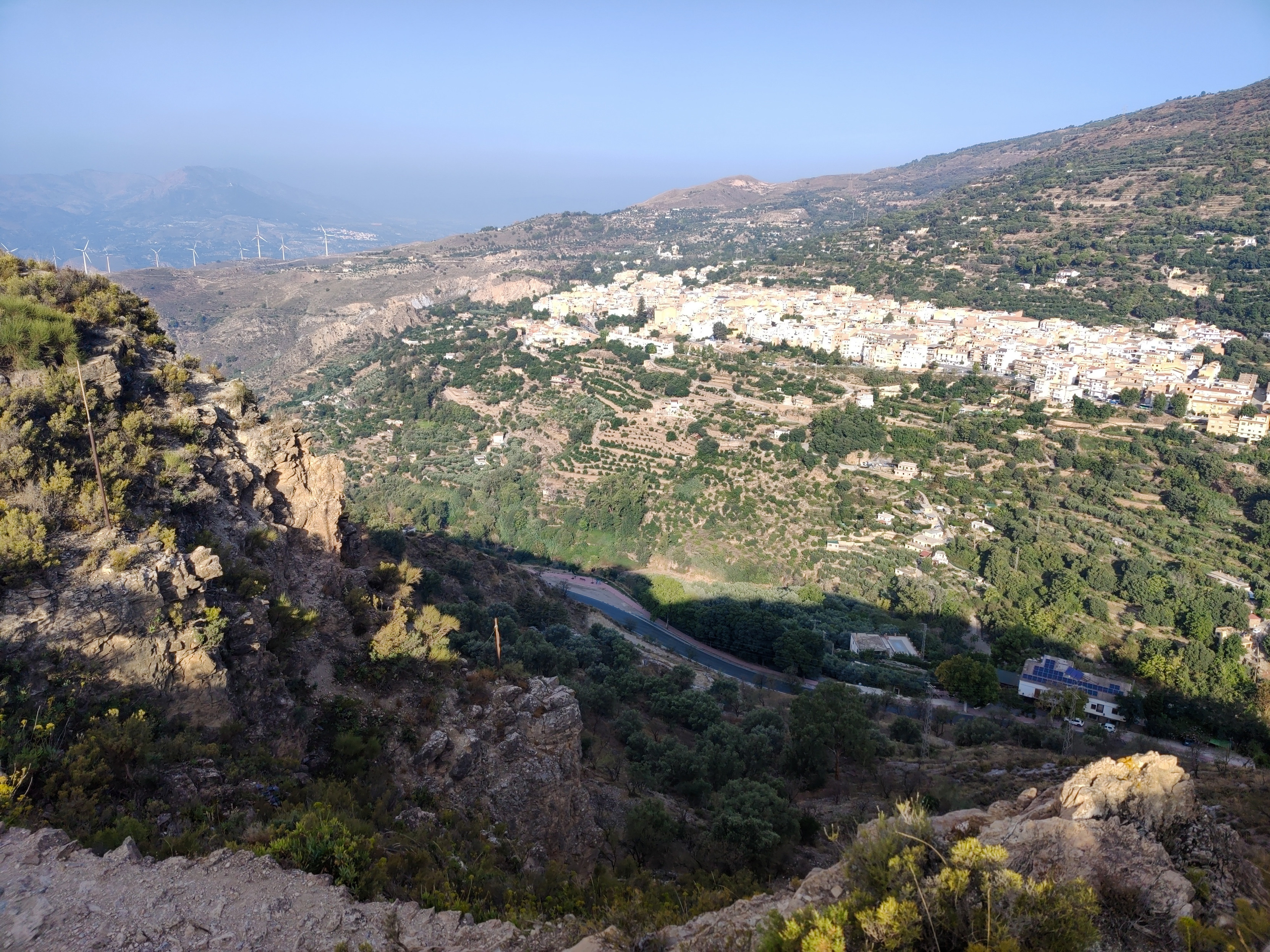 Some cliffs are highlighted in the morning sun. Below are the white rooftops of a Spanish town