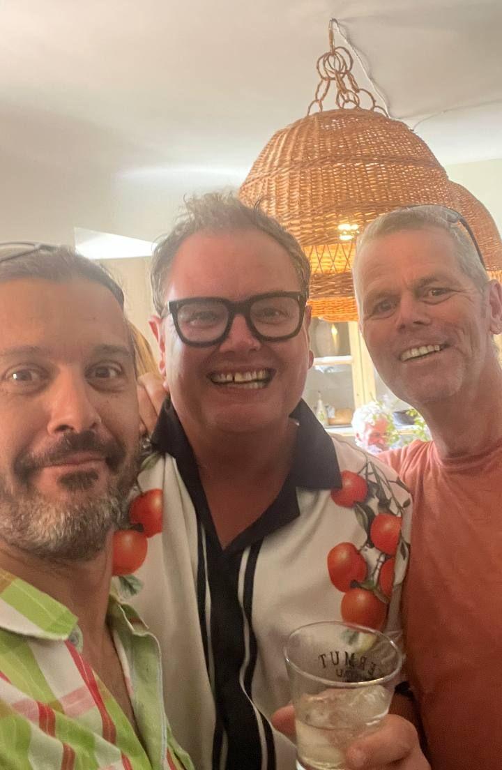 One famous celebrity (Alan Carr) and two much less know ones smile for the camera