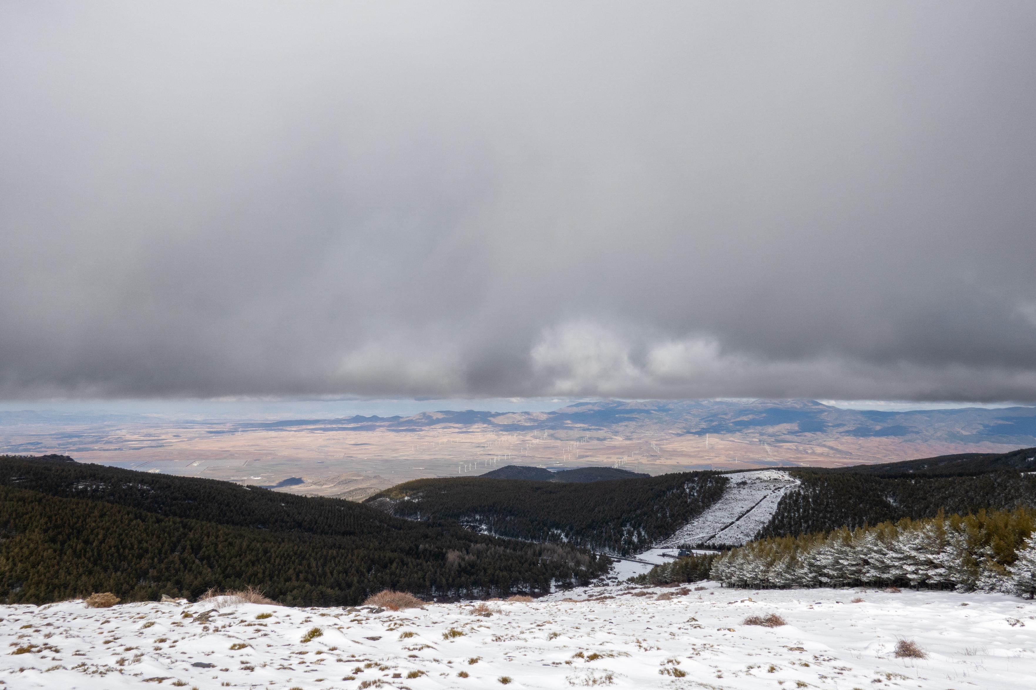 A strange horizontal window opened up below the vast expanse of grey skies. Views of snow and distant moubtain peaks
