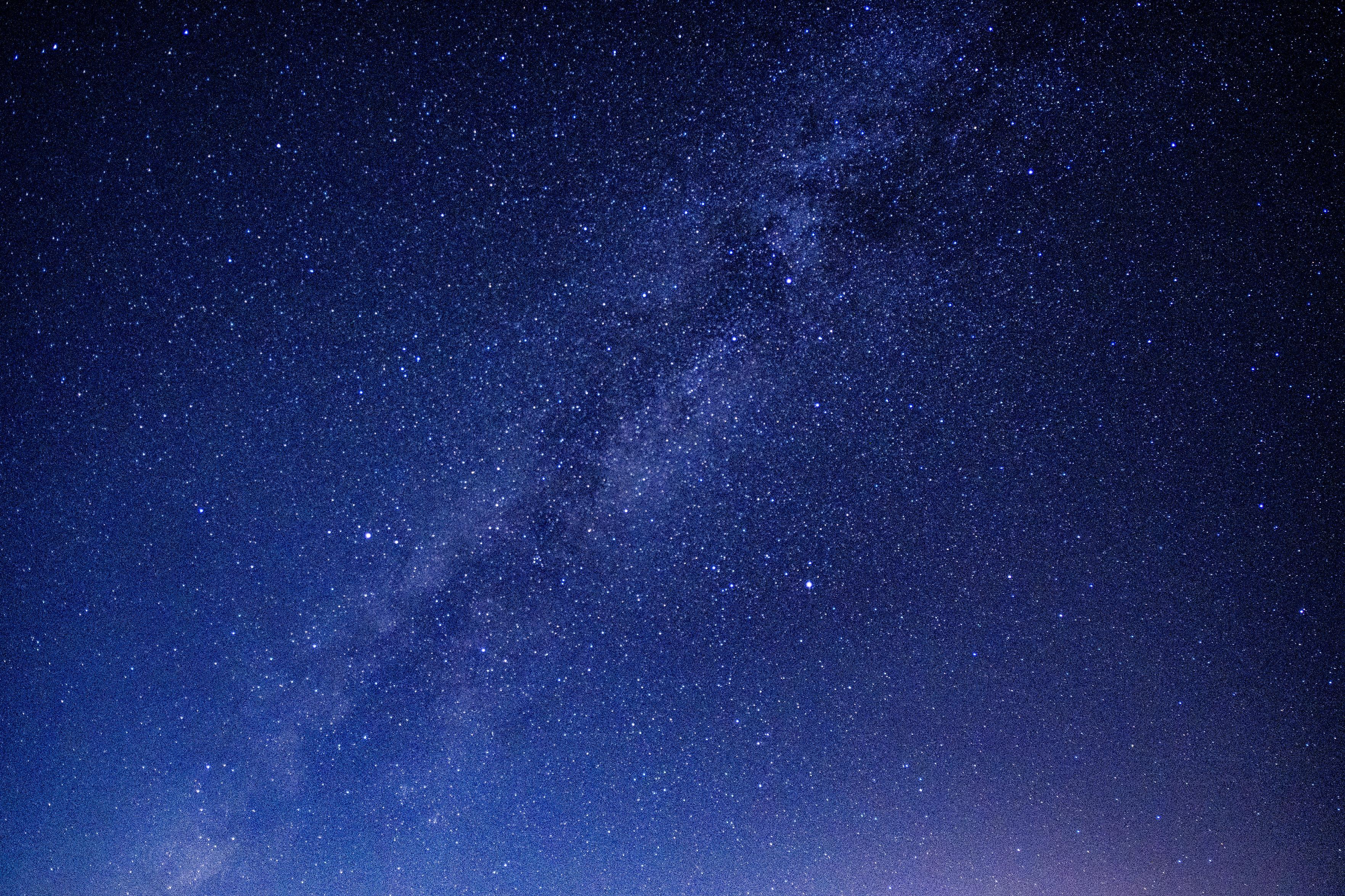 A photo of the milky way. Hundreds of stars fill the dark skies