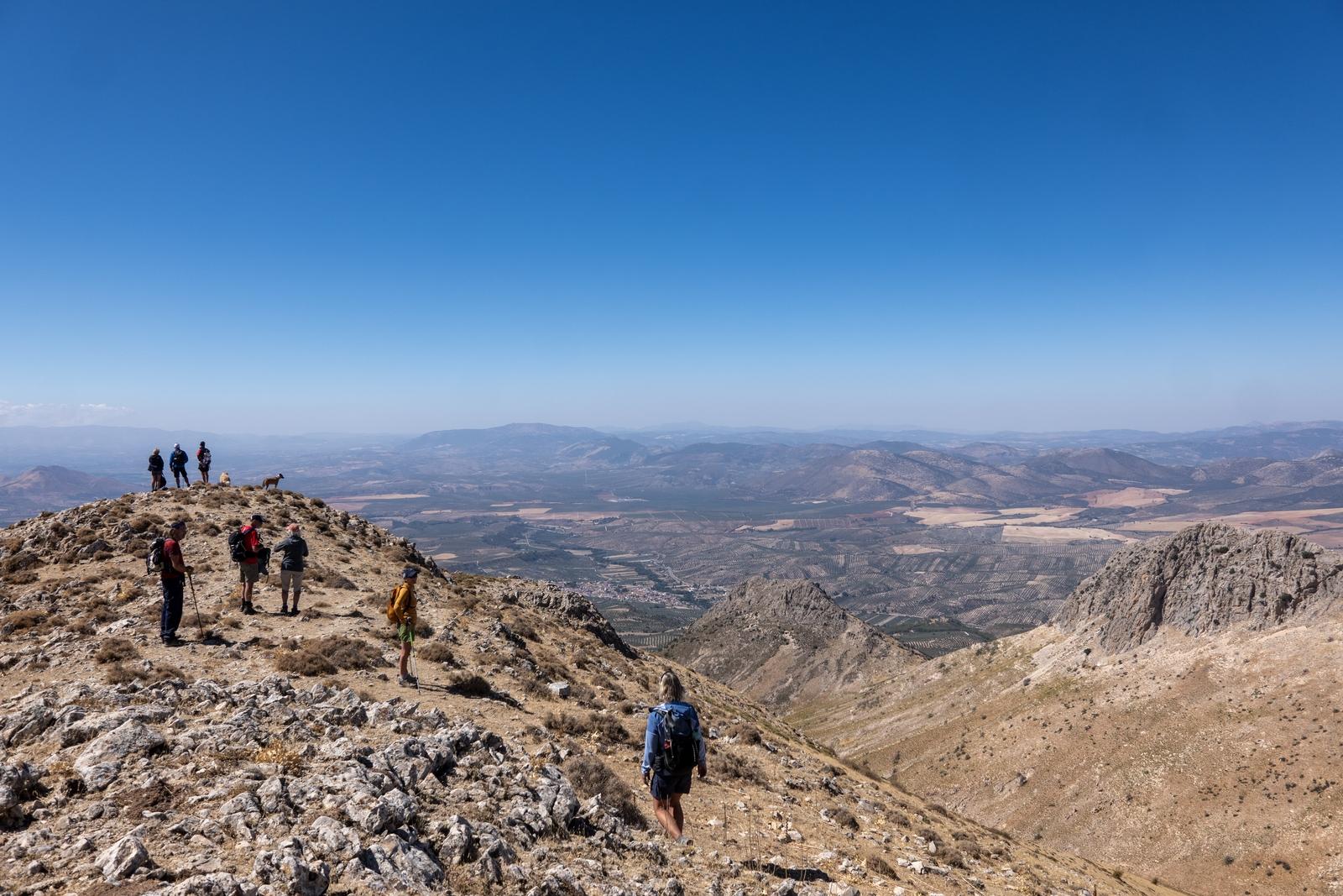 A hiking group on the broad ridge beyond Cerro Orduña