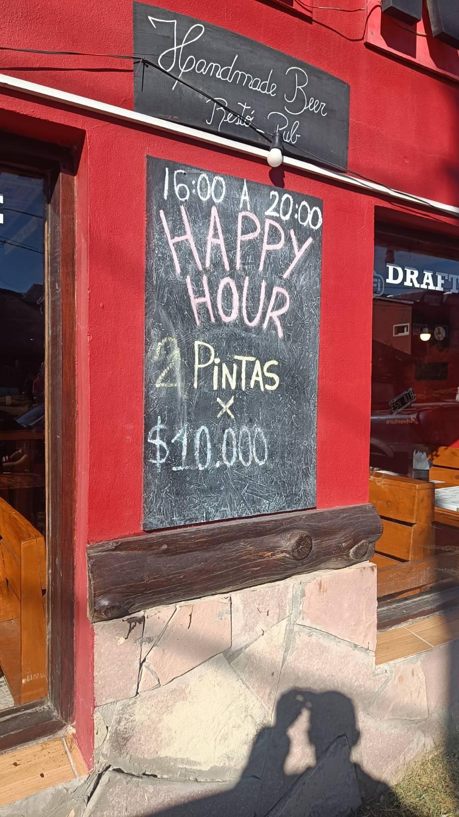 A chalkboard outside a bar advertising happy hour