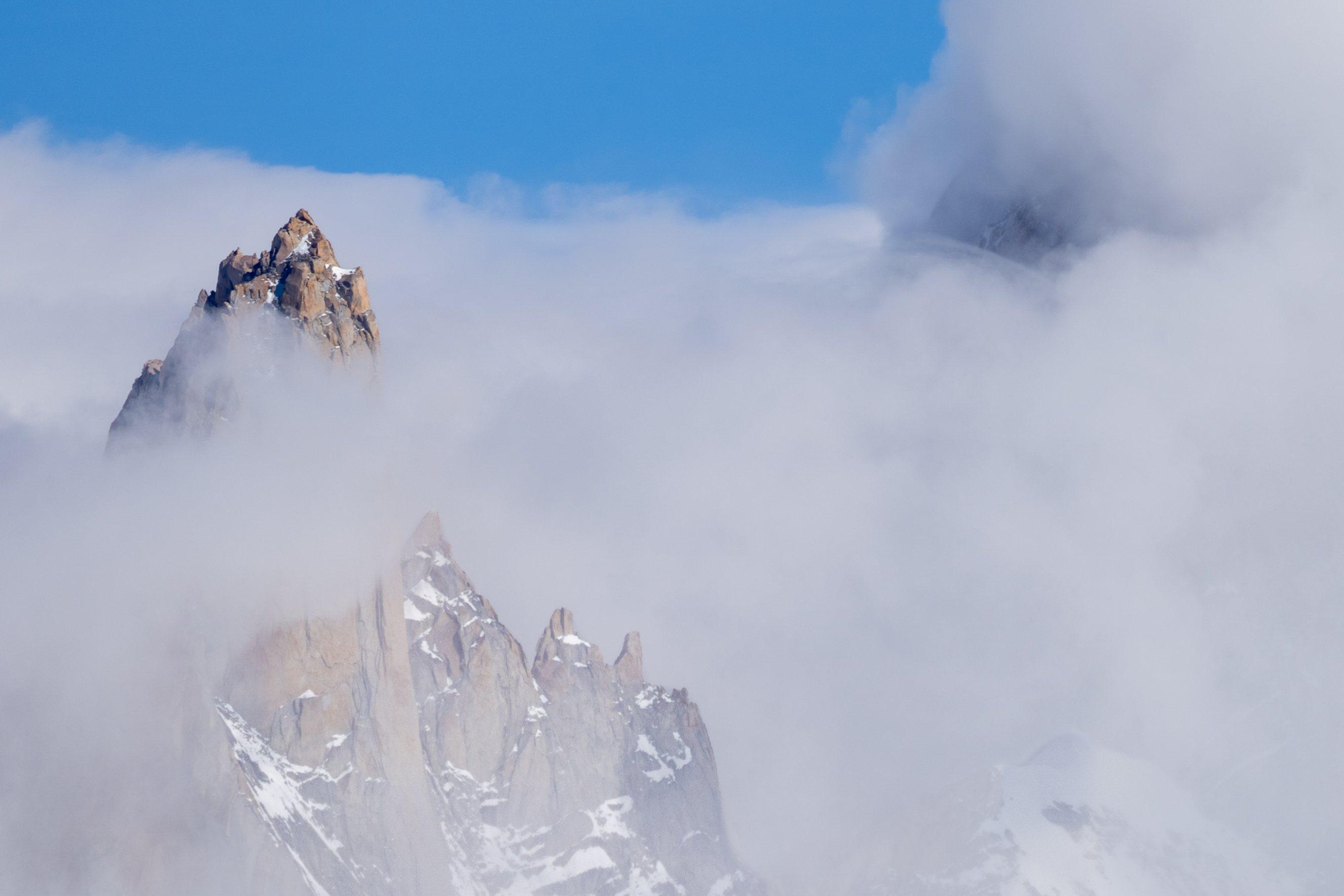 Aguja Poincenot peaks out above the white clouds