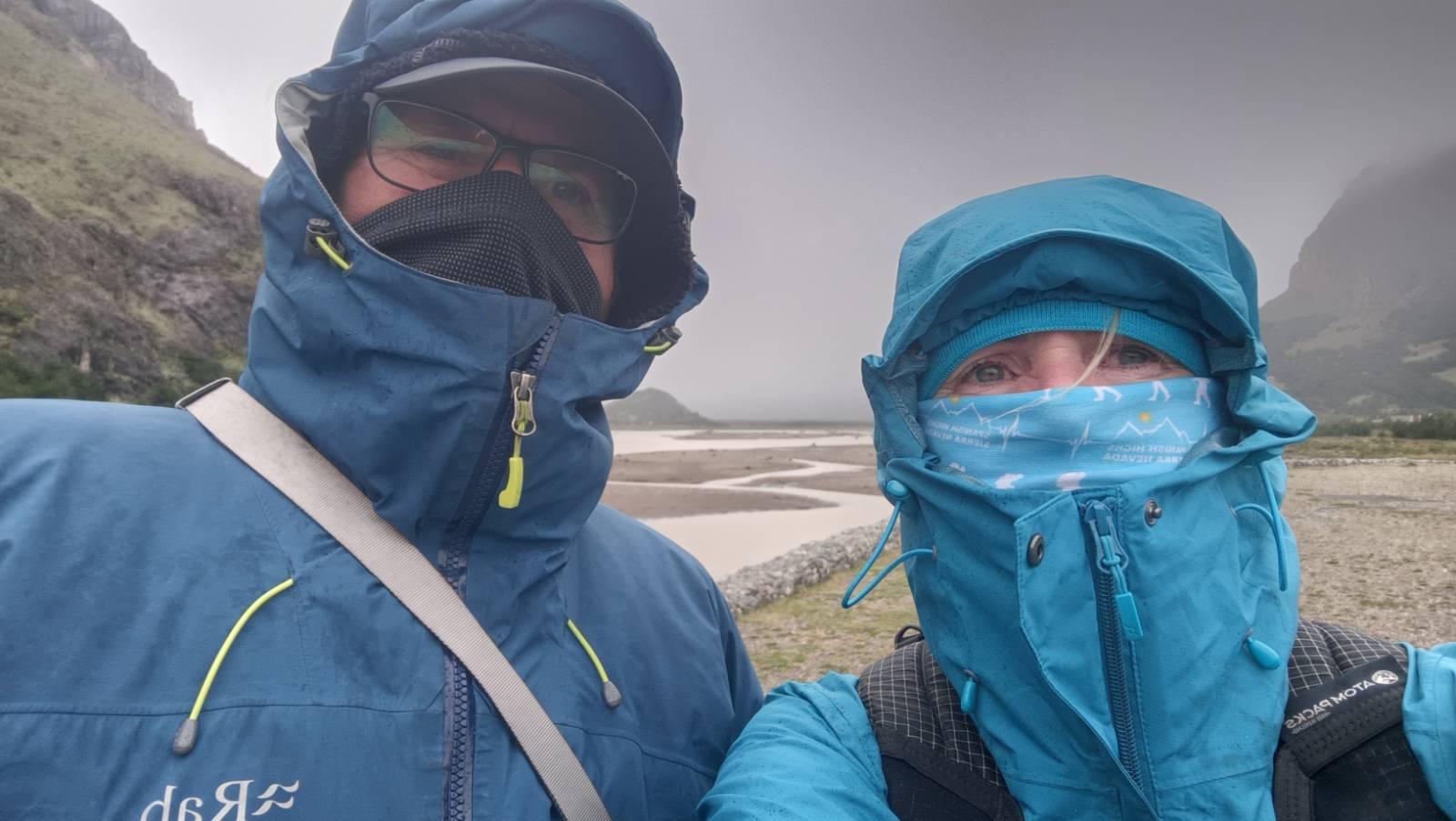Two people in balaclavas and rain jackets brave the cold and windy conditions