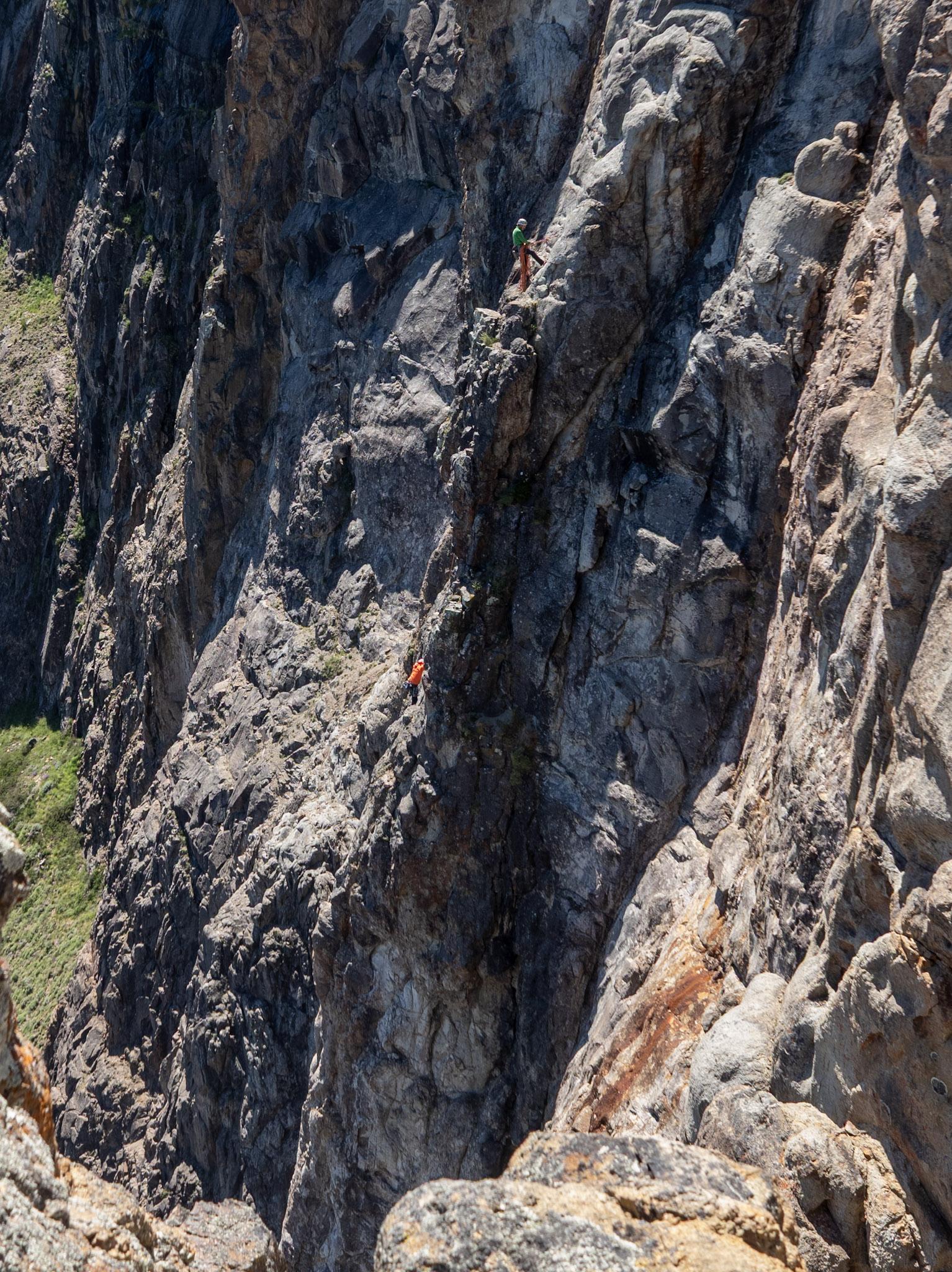 2 rock climbers cling to a near vertical cliff on the western side of Cerro Paredon