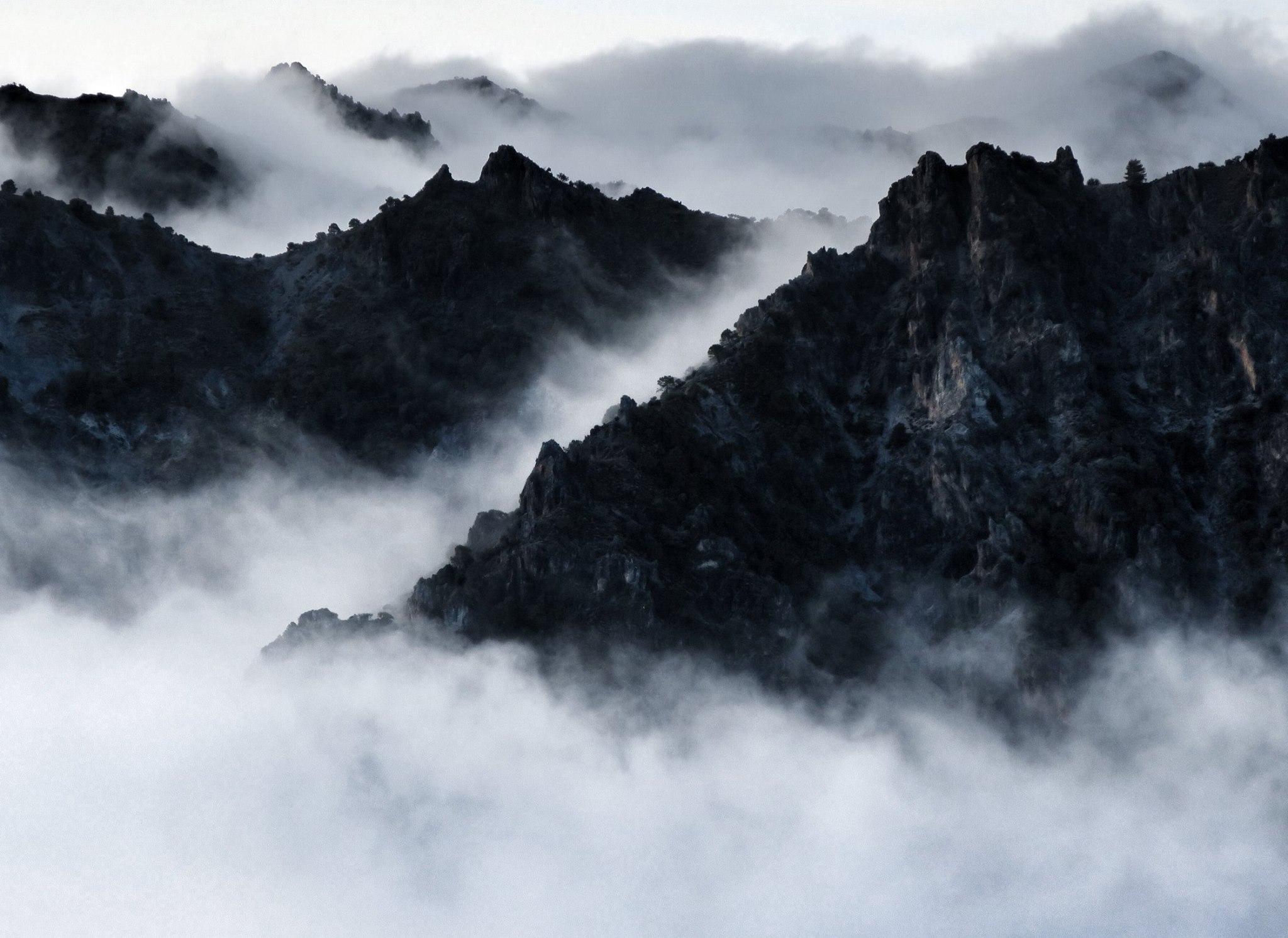 Cloud lies in the valleys but a series of jagged hillsides rises out of the cloud