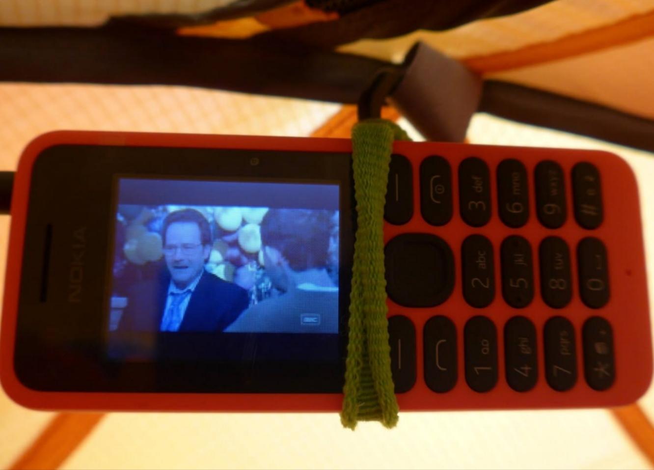 An old red Nokia phone hung up on the underside of an inner tent
