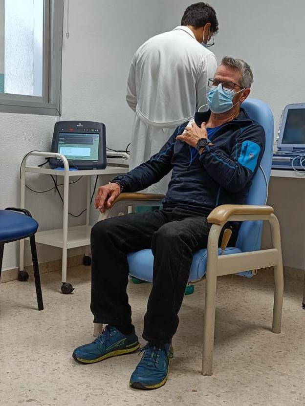 Me sat in a chair holding a Bluetooth pad whilst a medical consultant in white coat examines a computer screen