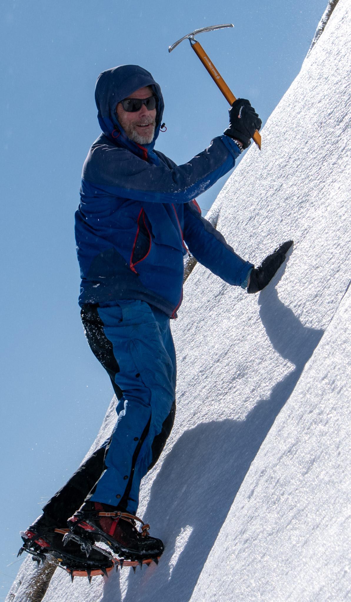 I am climbing on front point swinging an ice axe. Predominantly dressed in blue