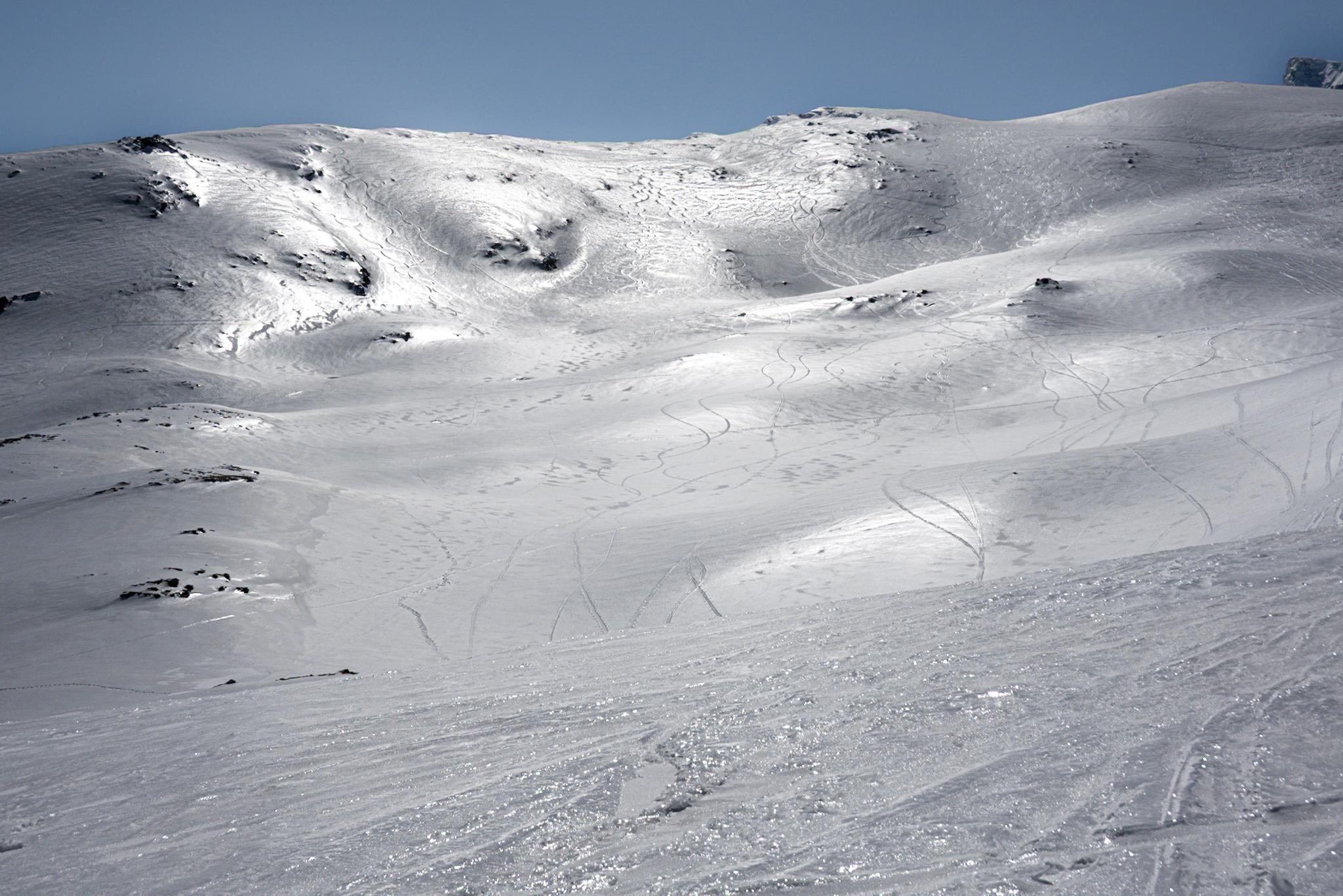 Sun shines and the ice glistens on snow covered hillsides