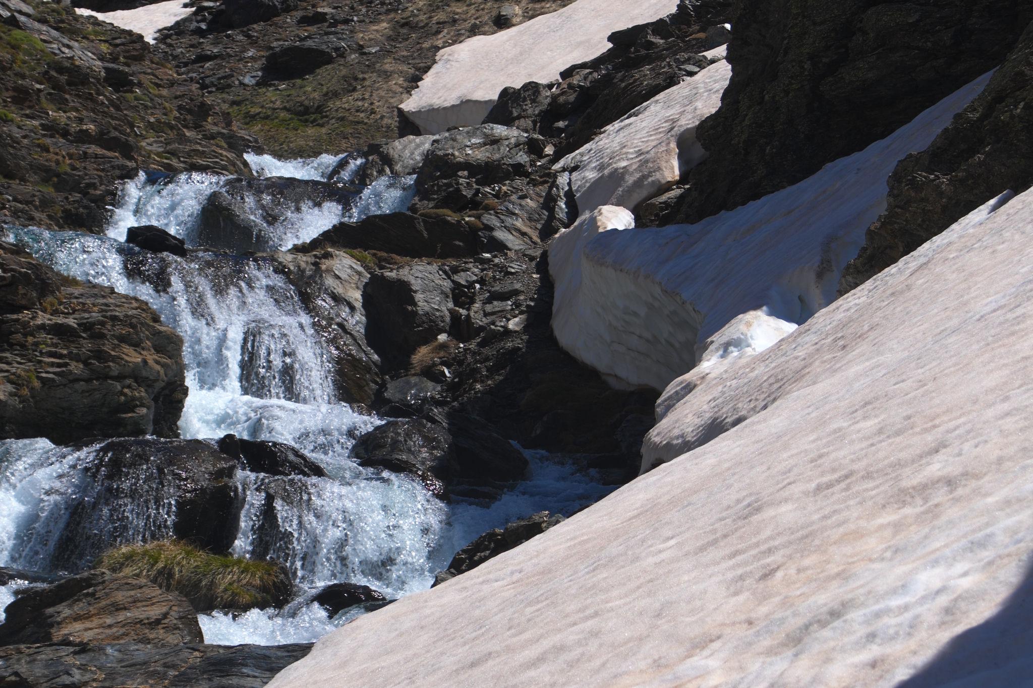 Remaining snow patches line the right hand banks of this river which is tumbling down a series of cascades
